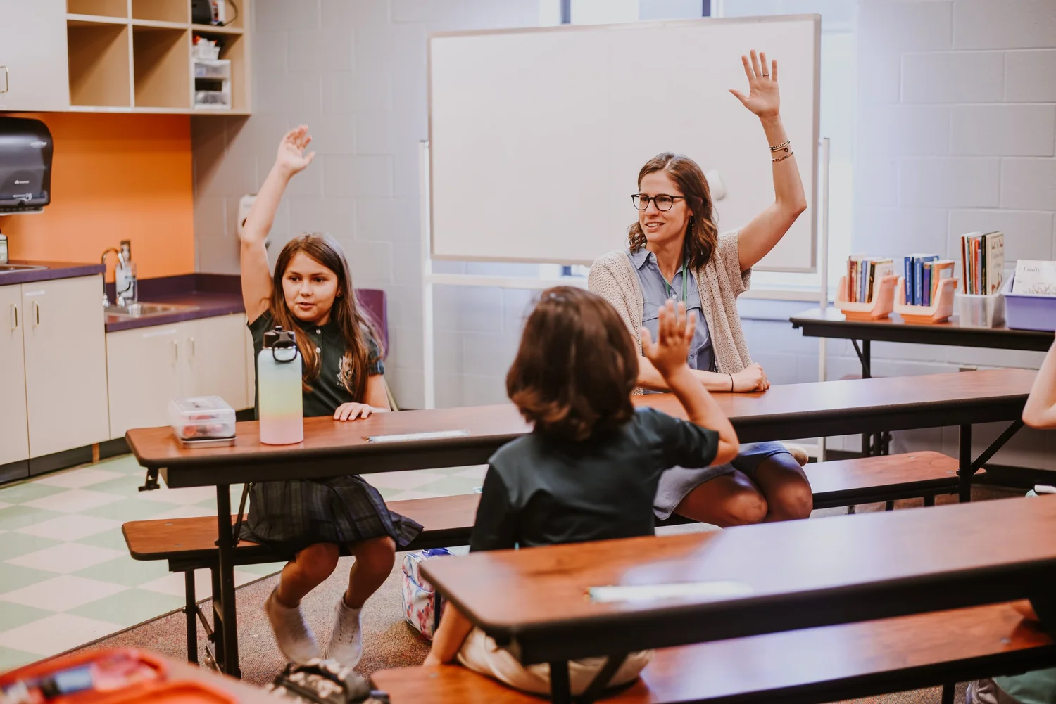 Young students eagerly raising their hands