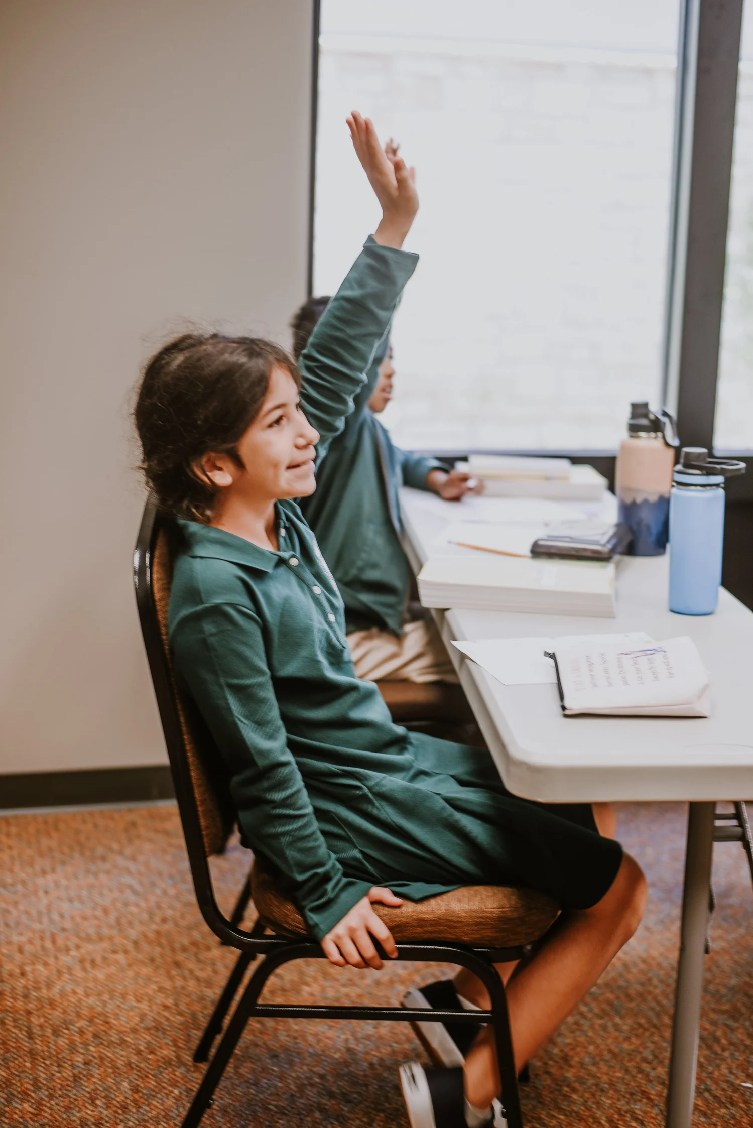 A student raising her hand in class