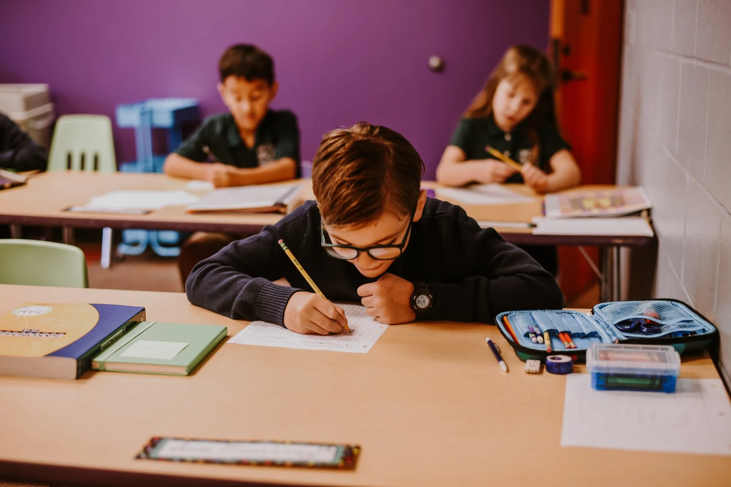A grammar school student writing in a notebook